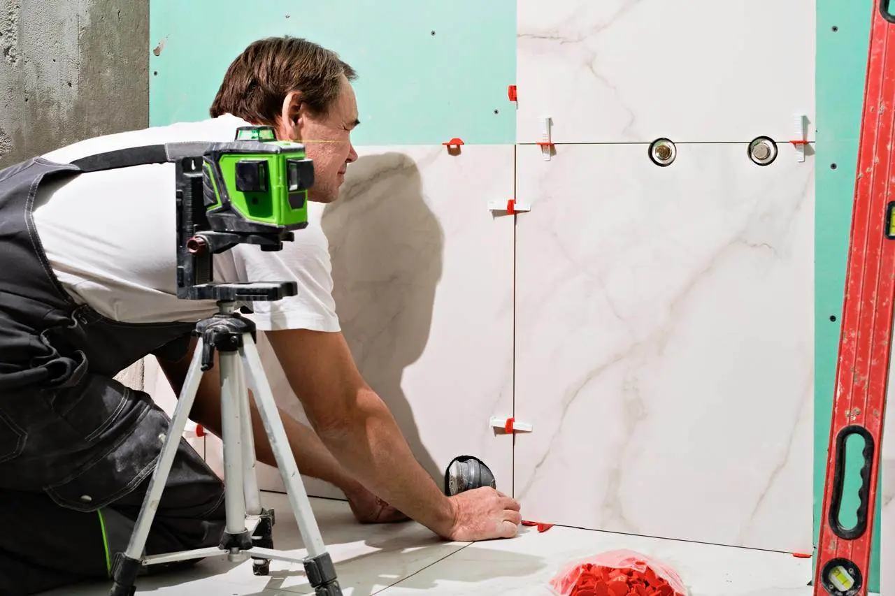 Applying grout between bathroom tiles to create clean and even grout lines